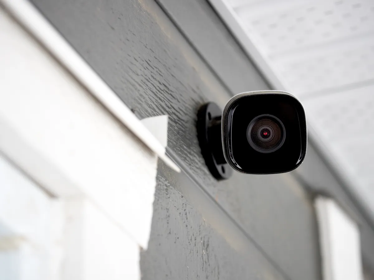 Black security camera installed on home exterior